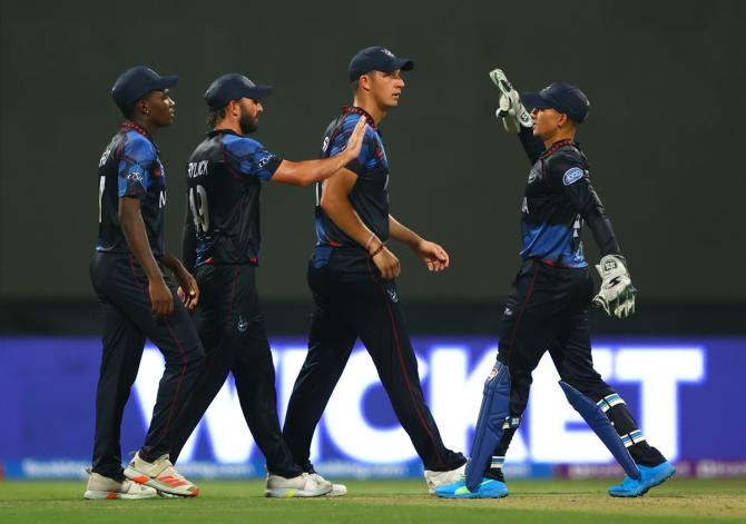 Namibia's Jan Frylinck and Zane Green celebrate the wicket of Pakistan's Babar Azam.