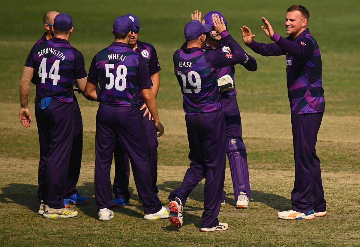 Scotland spinner Mark Watt celebrates the wicket of Devon Conway.