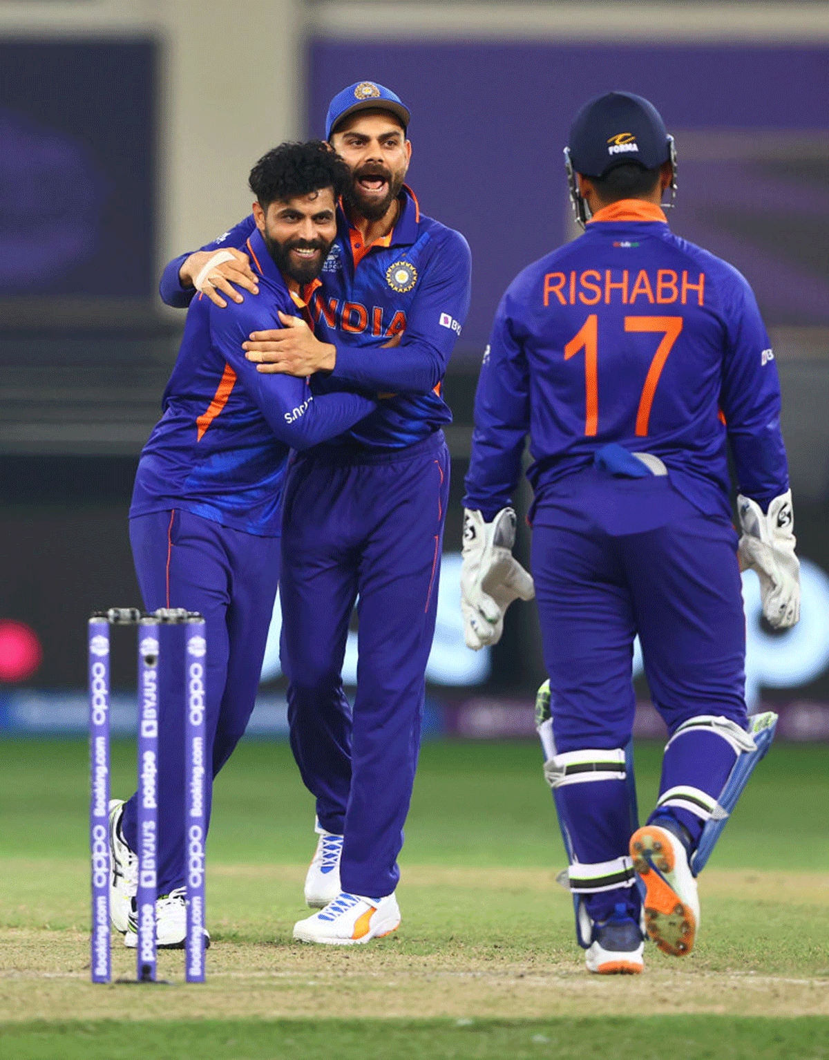 Ravindra Jadeja celebrates with Virat Kohli after taking the wicket of Scotland's Matthew Cross