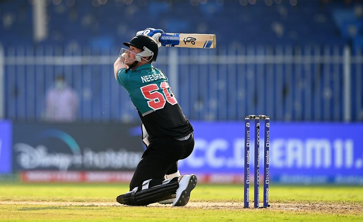  Jimmy Neesham steps out to send the ball to the boundary.