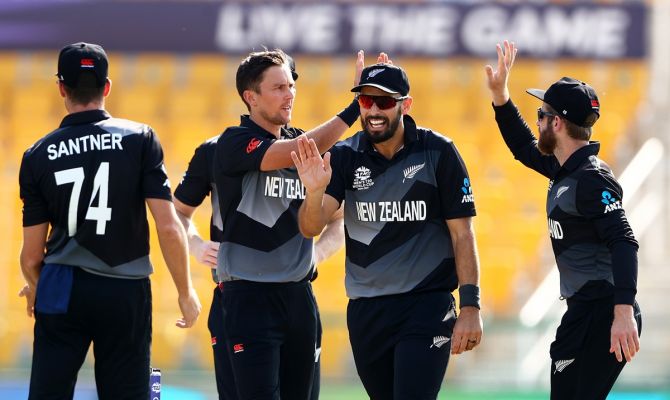 New Zealand pacer Trent Boult celebrates the wicket of Afghanistan's Hazratullah Zazai with skipper Kane Williamson during the T20 World Cup match, at Sheikh Zayed Stadium in Abu Dhabi, on Sunday.