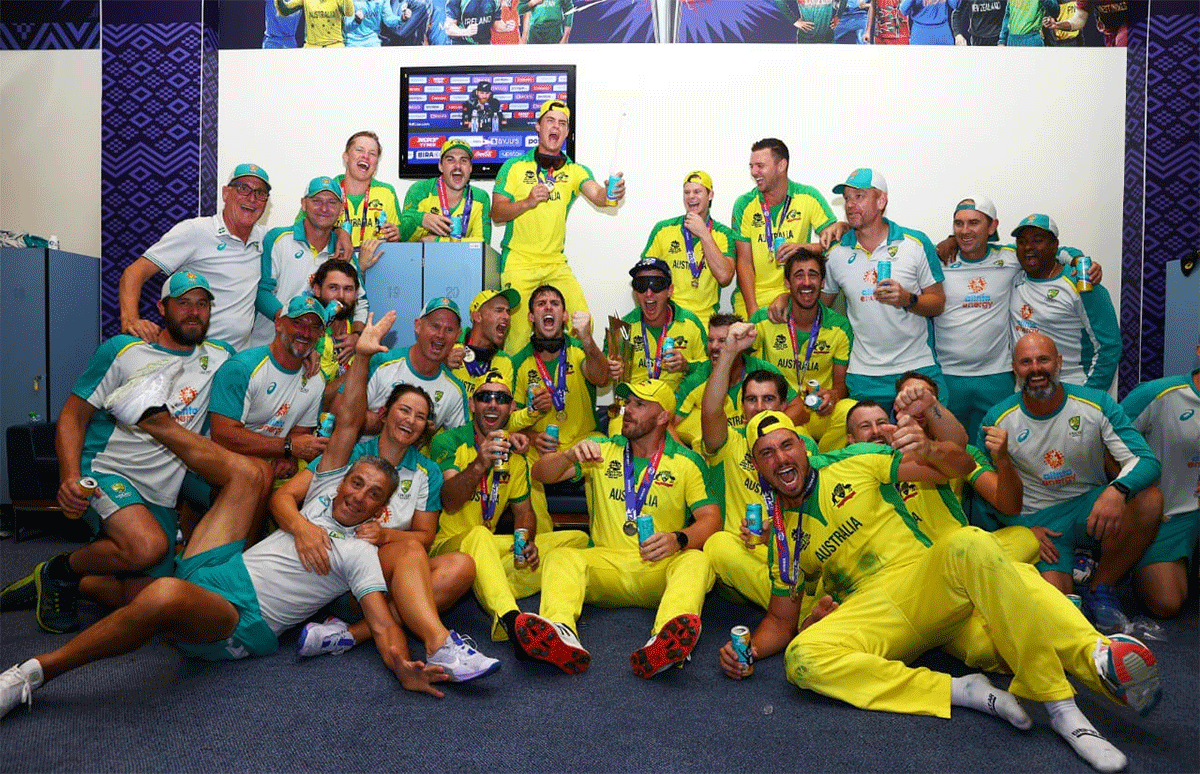 Australian cricketers and support staff celebrate in the dressing room