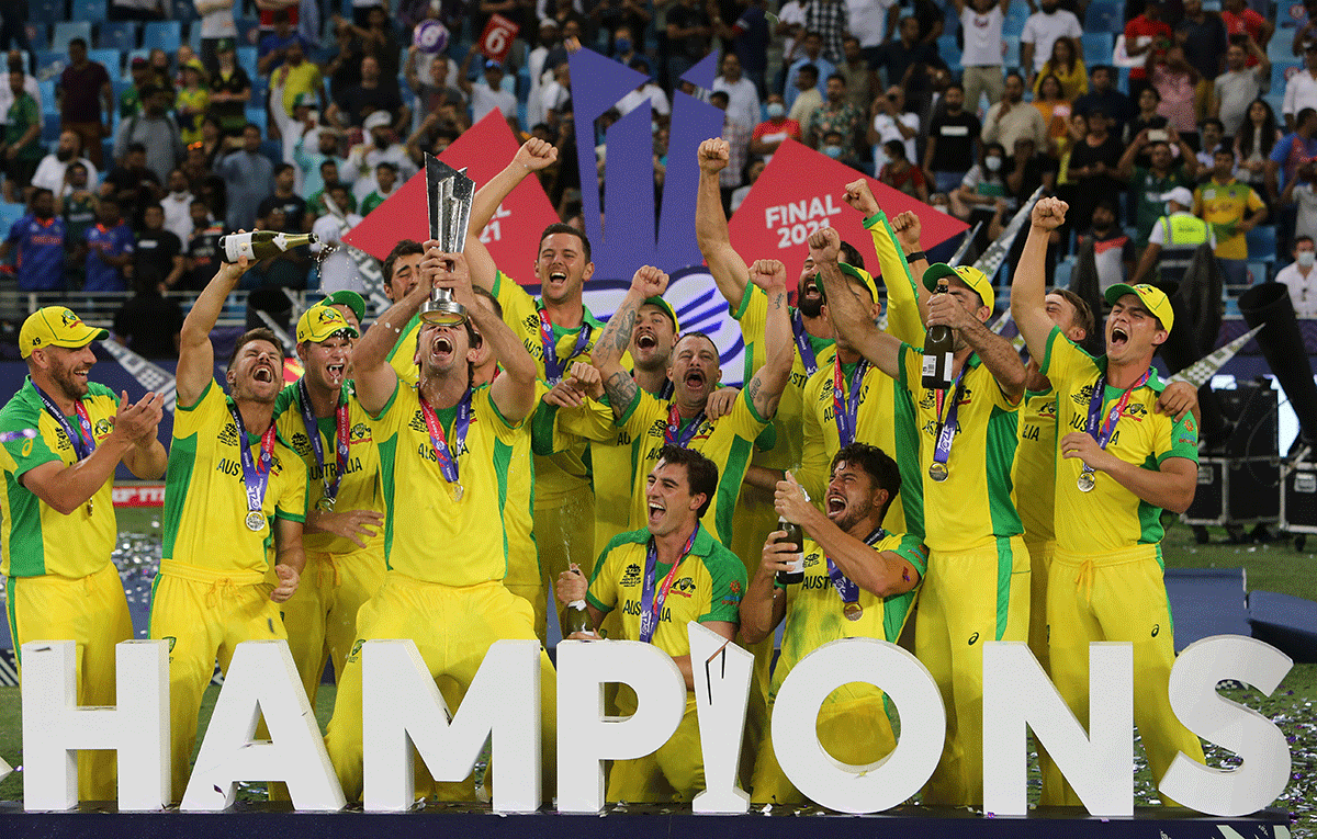 Australian players celebrate with the trophy after winning the ICC mens Twenty20 World Cup final match against New Zealand, at the Dubai International Cricket Stadium in Dubai, on Sunday