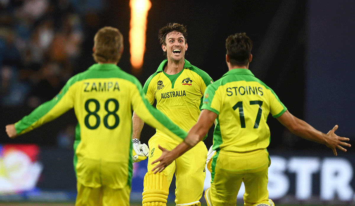 Australia's Mitchell Marsh celebrates with Marcus Stoinis and Adam Zampa after hitting the winning runs to win the ICC Men's T20 World Cup final match against New Zealand, at Dubai International Stadium in Dubai on Sunday