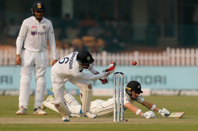 India's wicketkeeper Wridhhiman Saha makes a vain attempt to run-out William Young. 
