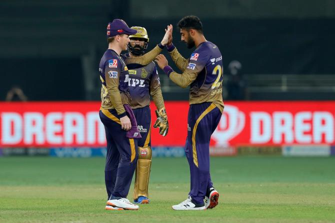 Varun Chakaravarthy is congratulated by skipper Eoin Morgan after taking the wicket of Mayank Agarwal.