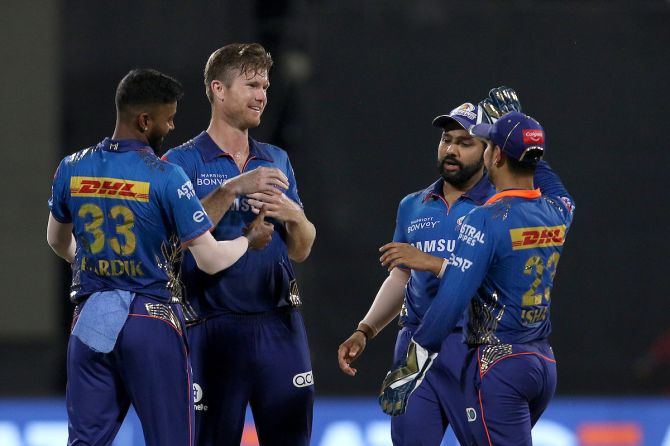 Mumbai Indians pacer James Neesham celebrates with teammates after taking the wicket of Shivam Dube during the IPL match against Rajasthan Royals, in Sharjah, on Tuesday.