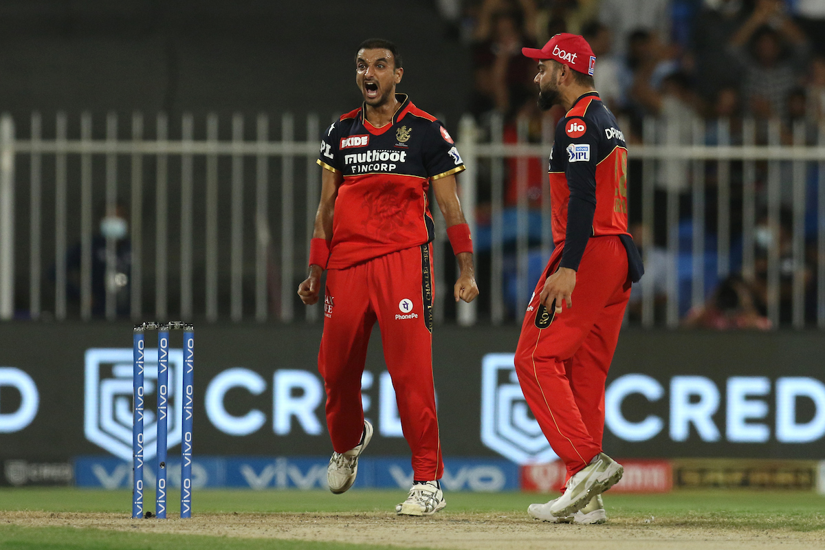 Harshal Patel celebrates with skipper Virat Kohli after dismissing Venkatesh Iyer.