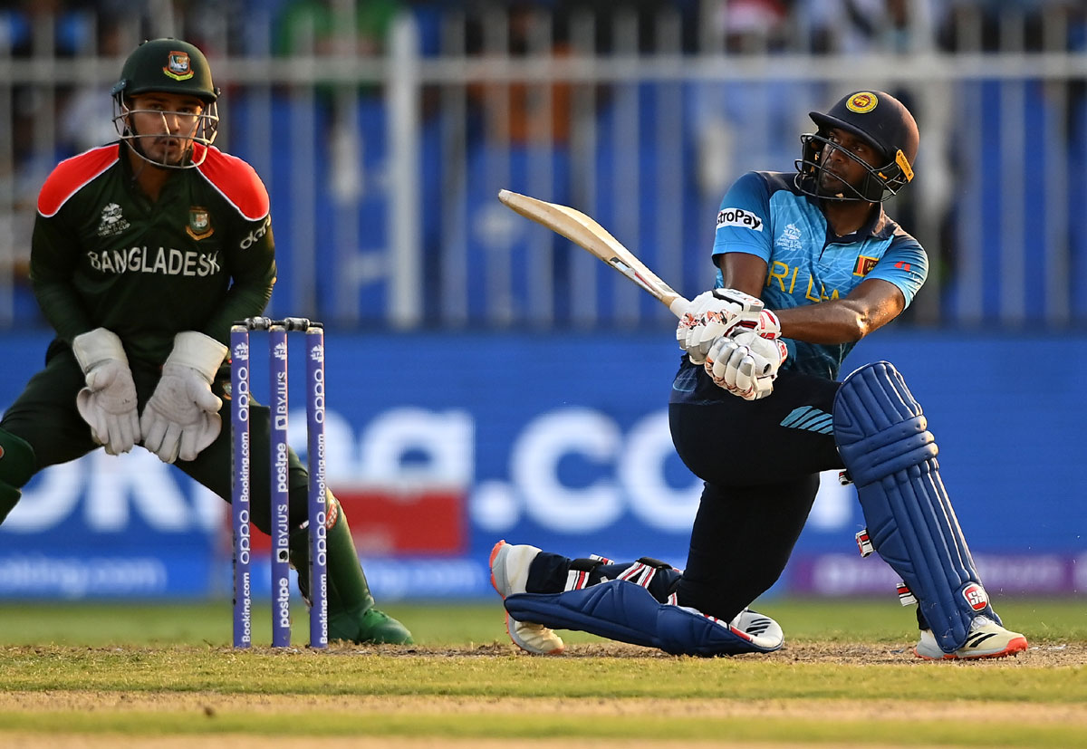 Bhanuka Rajapaksa plays a shot as Nurul Hasan of Bangladesh looks on