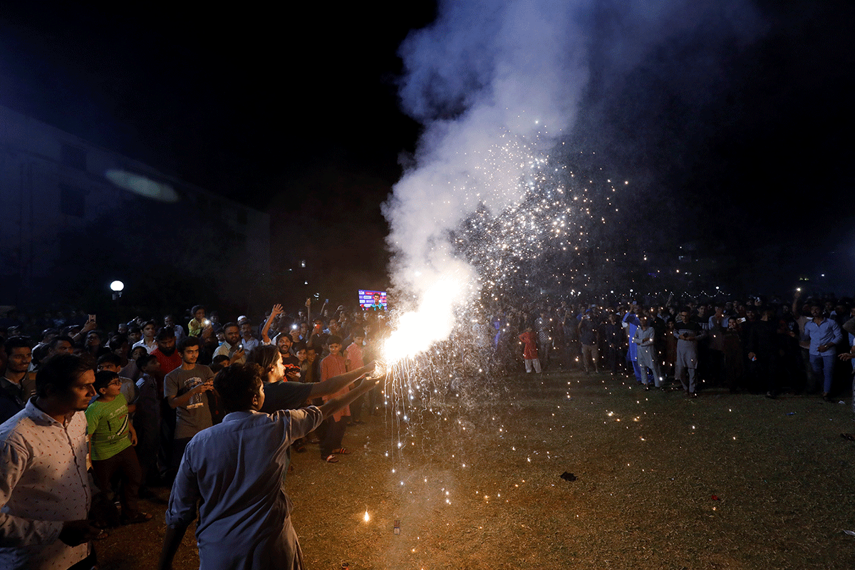 Pakistani cricket fans light fireworks as they celebrate at a park in Karachi after Pakistan's victory over India in the Twenty20 World Cup super 12 Stage match in Dubai on Sunday