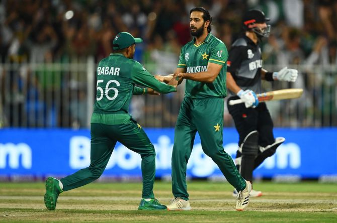 Imad Wasim is congratulated by teammate Babar Azam after taking of Daryl Mitchell.
