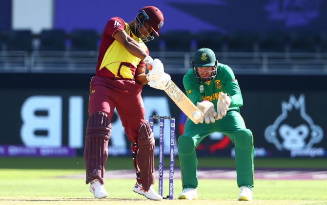 West Indies opener Evin Lewis hits a four as South Africa wicketkeeper Heinrich Klaasen looks on during the T20 World Cup match, at Dubai International Stadium, on Tuesday.