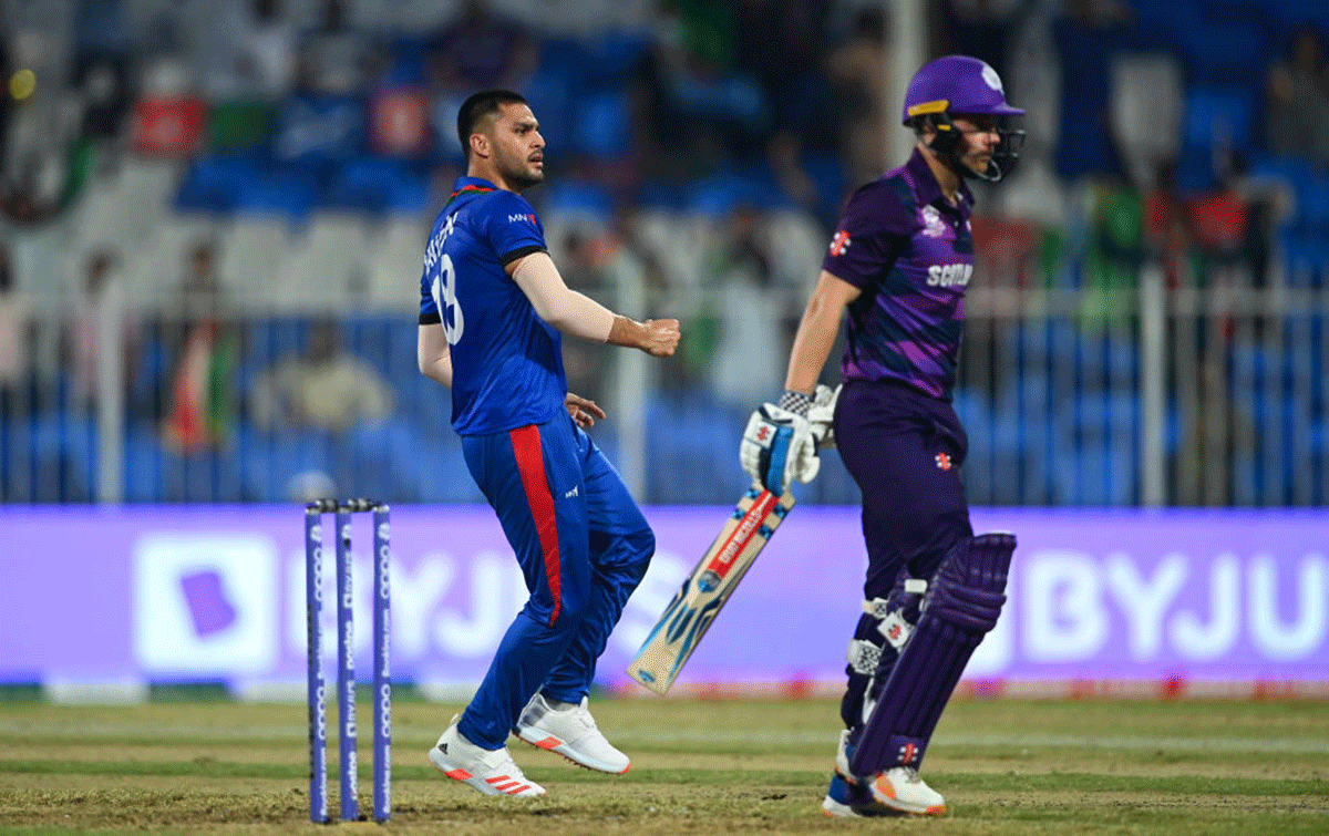 Afghanistan's Naveen-ul-Haq celebrates the wicket of Scotland's Matthew Cross during their ICC Men's T20 World Cup match at Sharjah Cricket Stadium in Sharjah on Monday