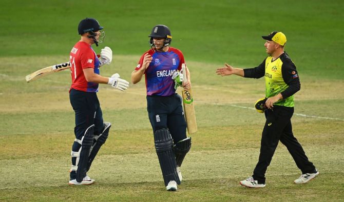  England's Jonny Bairstow and Jos Buttler are congratulated by Australia captain Aaron Finch after winning the T20 World Cup match in Dubai
