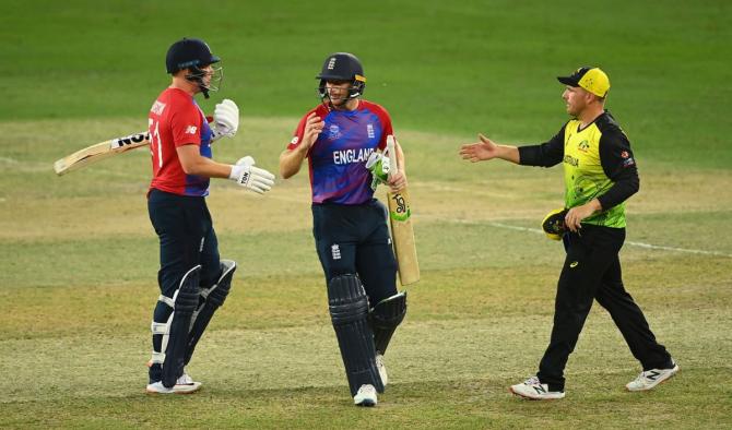  England's Jonny Bairstow and Jos Buttler are congratulated by Australia captain Aaron Finch after winning the T20 World Cup match in Dubai