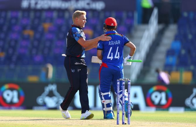 Asghar Afghan gets a bat on the back from Ruben Trumpelmann after being dismissed in his last match.