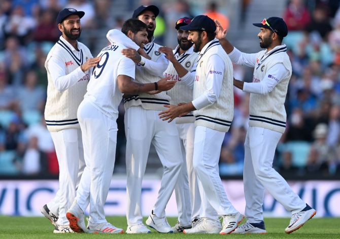 India pacer Umesh Yadav celebrates with teammates after dismissing England captain Joe Root.