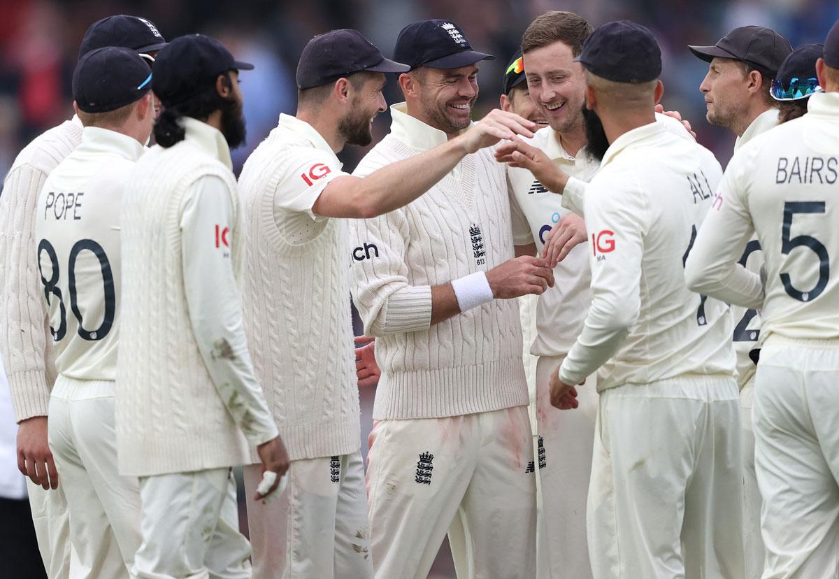 Ollie Robinson is congratulated after taking the wicket of Rohit Sharma.