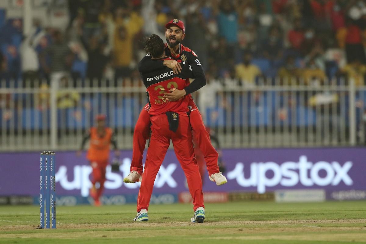 Glenn Maxwell celebrates with Virat Kohli after taking the wicket of Faf du Plessis.