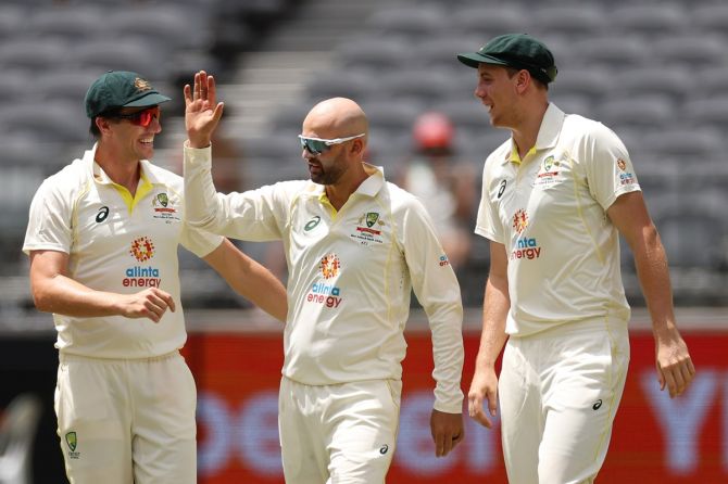 Australia spinner Nathan Lyon, centre, celebrates with Pat Cummins, left, and Cameron Green after dismissing Kraigg Braithwaite during Day 5 of the first Test against the West Indies, at Optus Stadium in Perth, on Sunday.