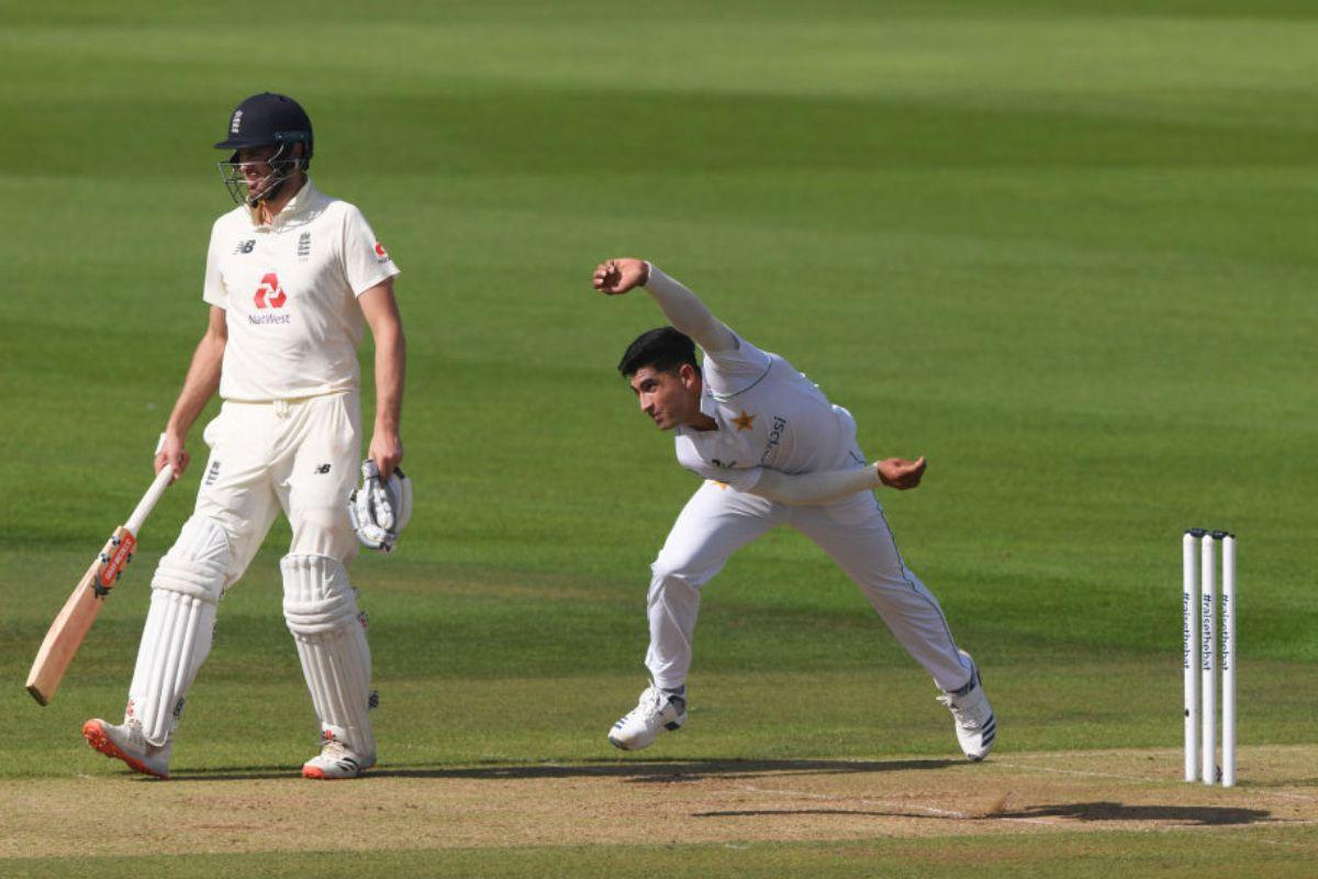 Naseem Shah of Pakistan(R) in bowling action as Dominic Sibley of England(L) looks on