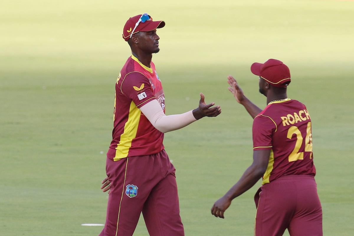 Jason Holder celebrates with Kemar Roach after dismissing Mohammed Siraj.