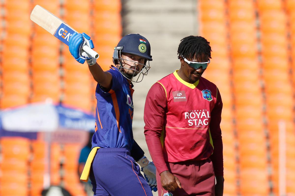 India's Shreyas Iyer raises his bat in celebration after completing a half-century.