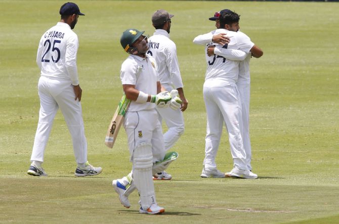 India's players celebrate as South Africa captain Dean Elgar walks back after his dismissal.