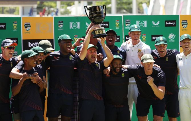 South Africa skipper Dean Elgar celebrates with teammates and the trophy after winning the third Test and series against India  at Newlands Cricket Ground, Cape Town, on Friday.