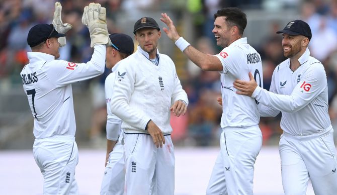 James Anderson celebrates with teammates after taking the wicket of Cheteshwar Pujara