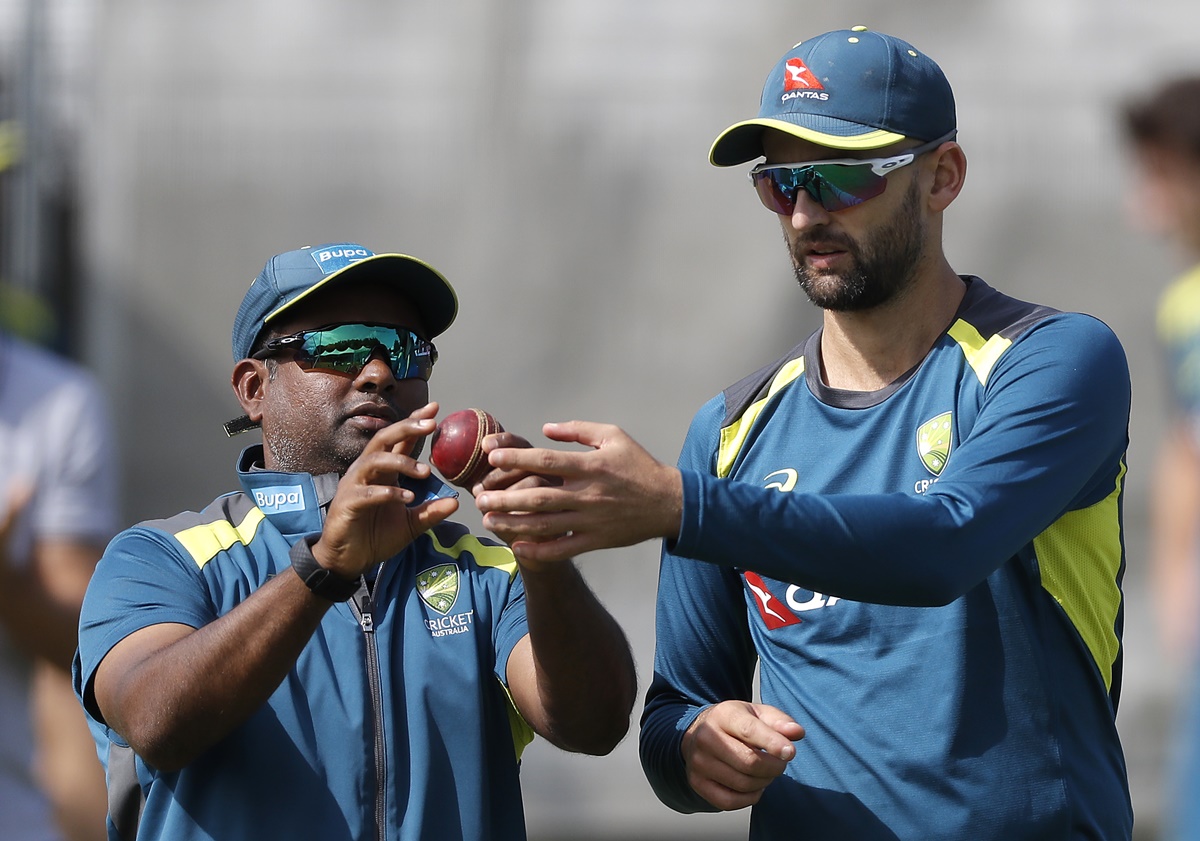 Australia's spin coach Sridharan Sriram explains the finer nuances of spin bowling to Nathan Lyon during an Australia nets session at Lord's Cricket Ground, London, on August 12, 2019.