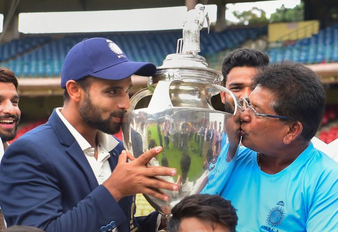 Madhya Pradesh captain Aditya Shrivastava and head coach Chandrakant Pandit kiss the Ranji Trophy after victory over Mumbai in the final at the M Chinnaswamy Stadium in Bengaluru, on Sunday.