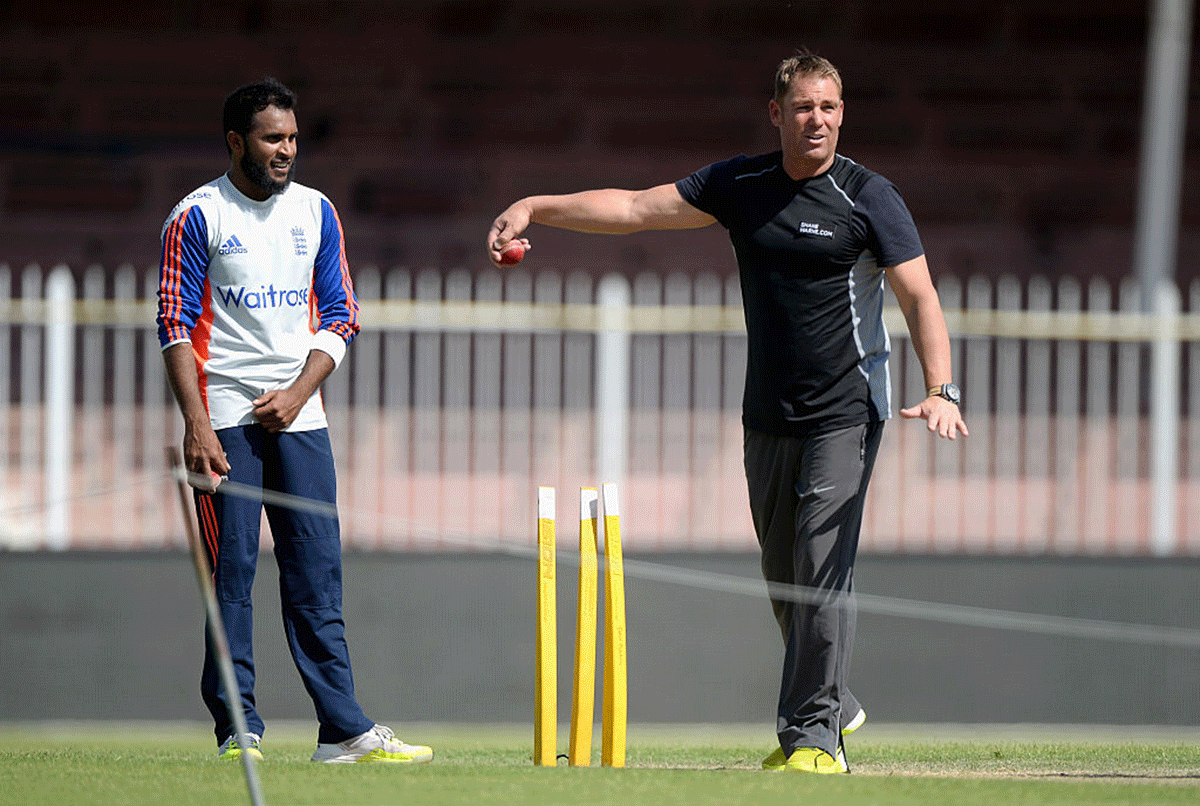 Former Australia bowler Shane Warne coaches England's Adil Rashid during a nets session at Sharjah Cricket Stadium in Sharjah, United Arab Emirates, on October 30, 2015 