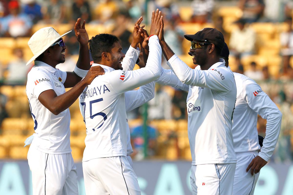 Dhananjaya de Silva celebrates with teammates after dismissing Rohit Sharma.