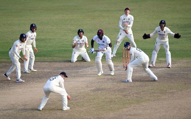 The West Indies's Jason Holder scores a run surrounded by England's close-in fielders during Day 5 of the first Test.