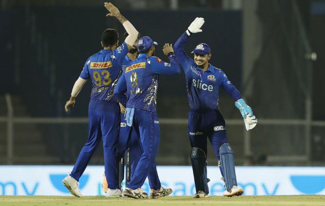 Mumbai Indians' players celebrate the wicket of Hardik Pandya