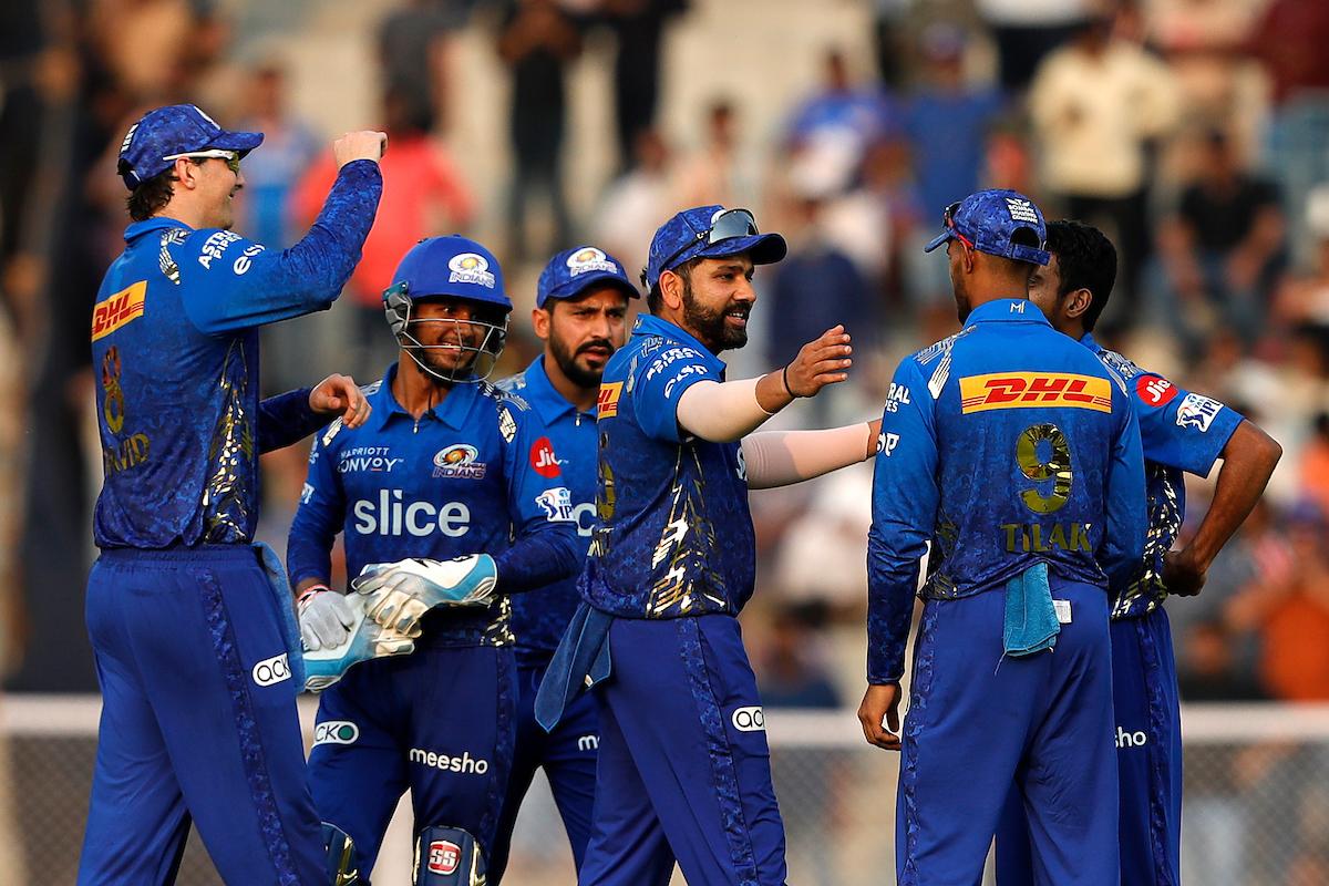 Mumbai Indians players celebrate the fall of a wicket