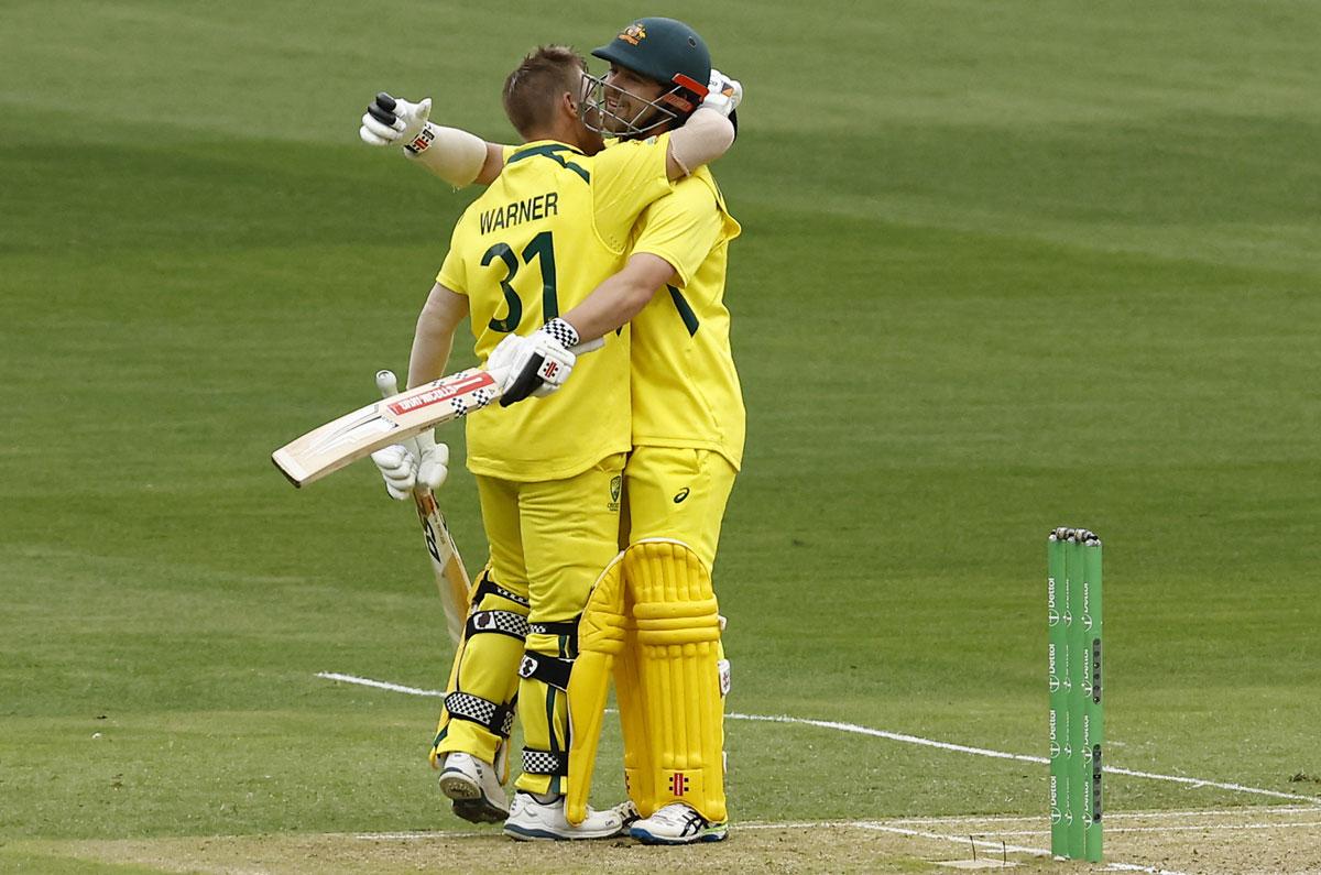 David Warner embraces Travis Head after scoring 100.