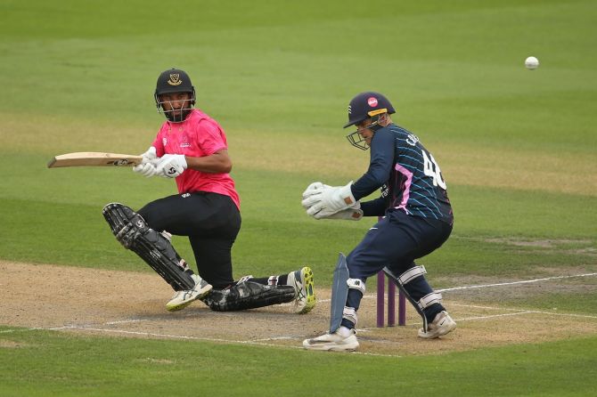 Sussex's Cheteshwar Pujara plays a shot as Middlesex's Joe Cracknell looks on during the Royal London Cup match at the 1st Central County Ground in Hove, England, on August 23, 2022. 