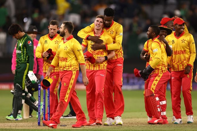 Blessing Muzarabani and Bradley Evans celebrate as the victorious Zimbabwe players walk back after the match.
