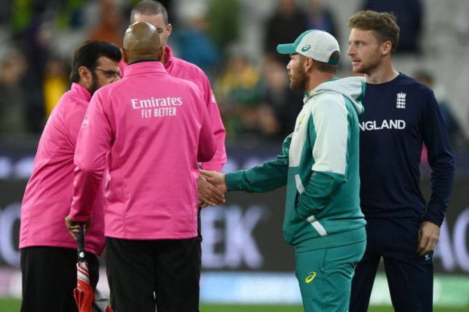 Jos Buttler of England and Aaron Finch of Australia shake hands with the umpires
