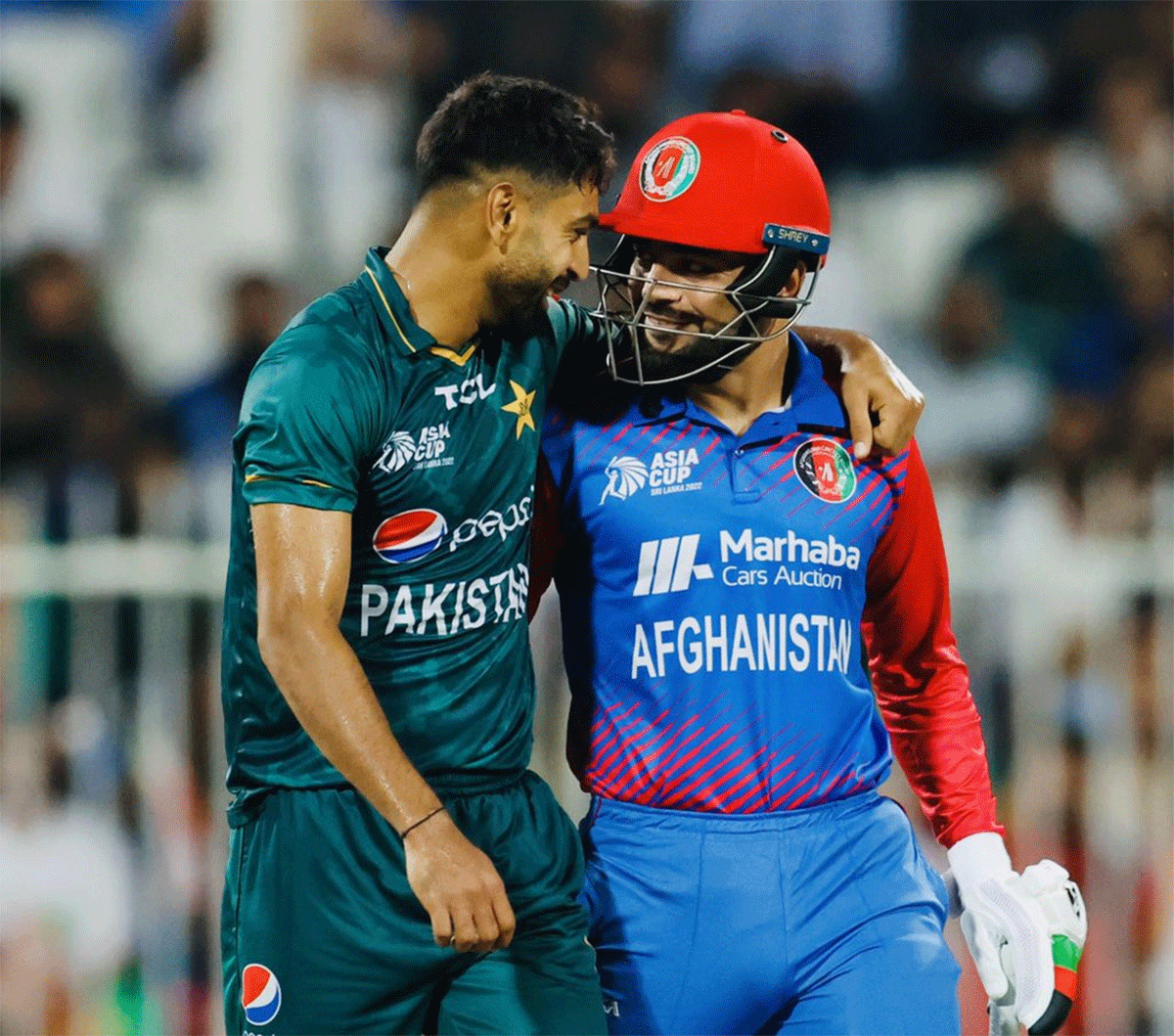 Pakistan's Haris Rauf and Afghanistan's Rashid Khan share a smile during their Asia Cup match in Sharjah on Wednesday