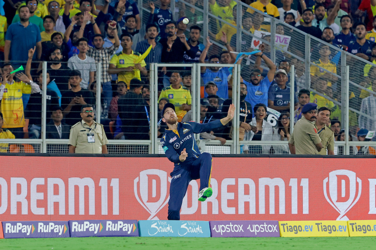 Kane Williamson makes an attempt to step back over the boundary after releasing the ball to catch it again.