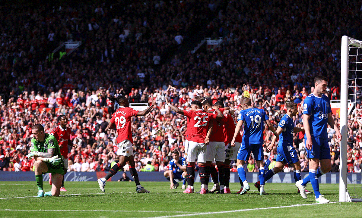 Everton players wear a dejected look as Manchester United's Anthony Martial celebrates scoring their second goal with teammates