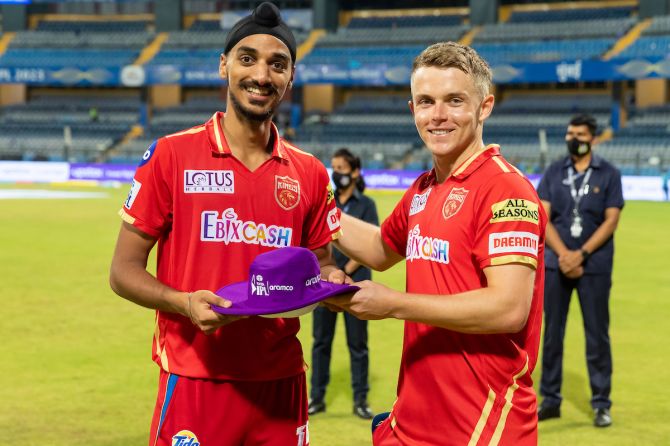 Arshdeep Singh, who finished with splendid figures of 4 for 29, receives the Purple cap from Punjab Kings skipper Sam Curran after the IPL match against Mumbai Indians, at the Wankhede stadium, in Mumbai, on Saturday.