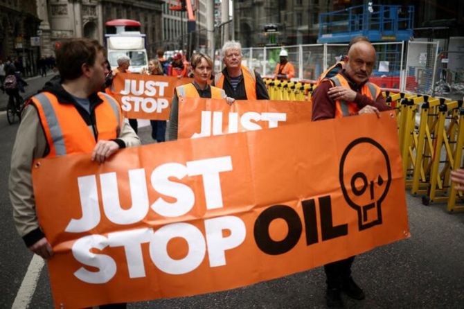 Activists from Just Stop Oil take part in a slow march along a road in the City of London financial district in London, Britain May 22, 2023
