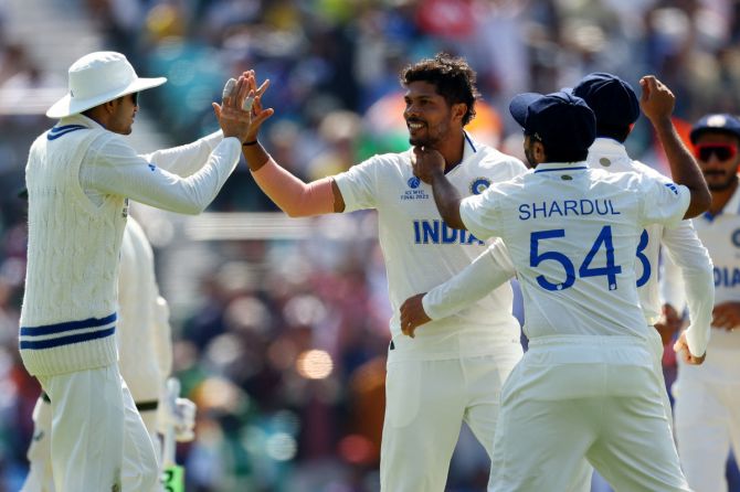 India's Umesh Yadav celebrates with teammates after taking the wicket of Australia's Usman Khawaja