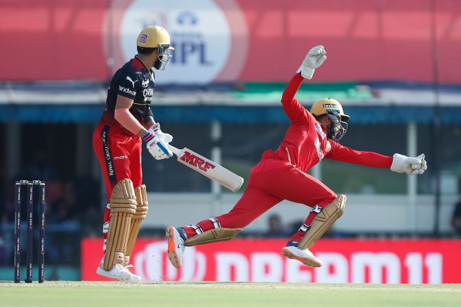 Punjab Kings wicketkeeper Jitesh Sharma catches Royal Challengers Bangalore's Virat Kohli during the Indian Premier League match at the I S Bindra Stadium, in Mohali, on April 20, 2023.