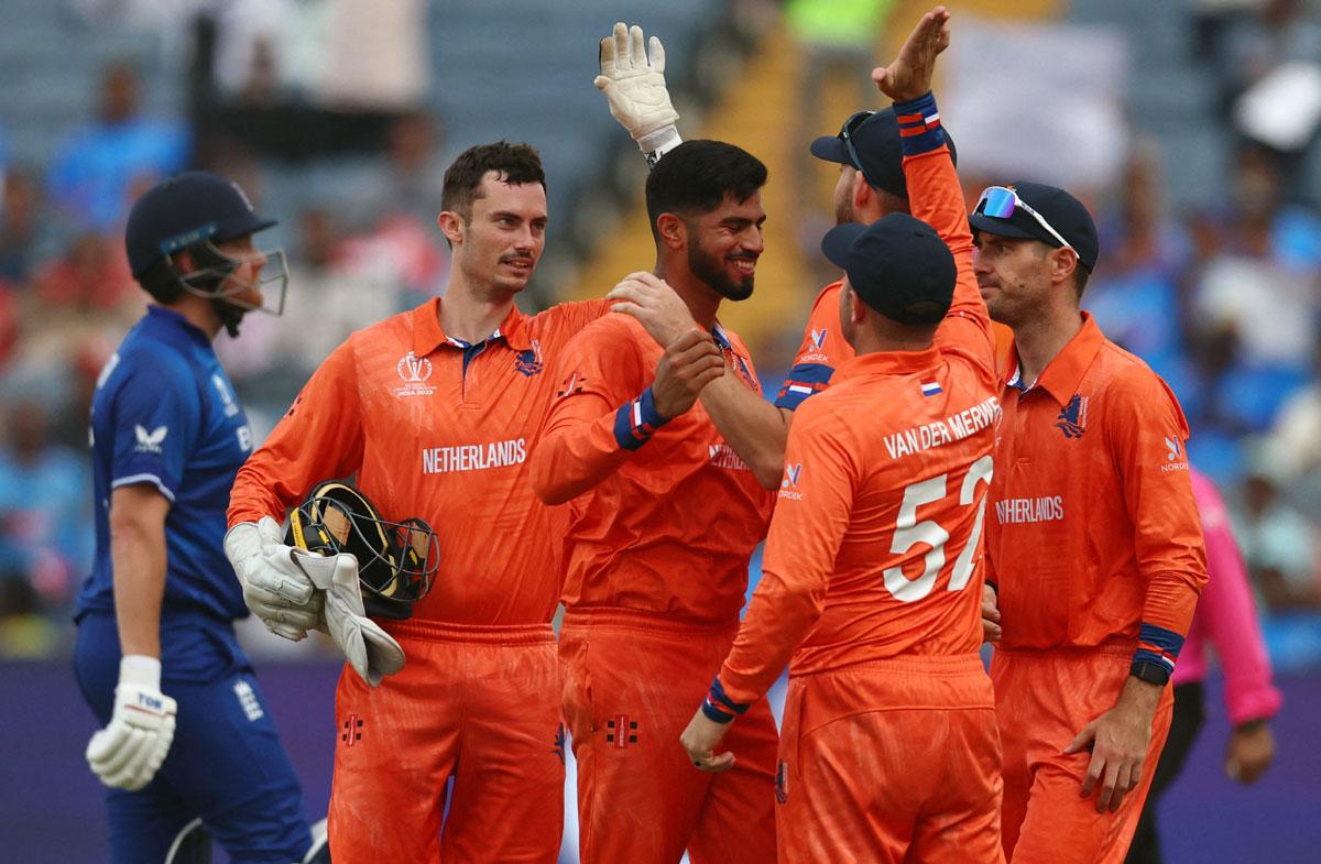 Aryan Dutt celebrates with Scott Edwards and teammates after dismissing England opener Jonny