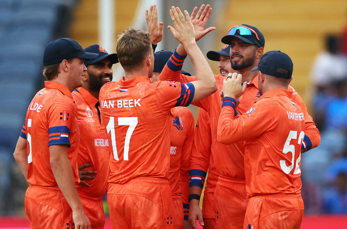 Logan van Beek celebrates with teammates after taking the wicket of Joe Root